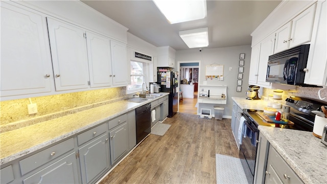 215 E Winter Ave, Danville, IL 61832 - kitchen with black appliances, light wood-style floors, white cabinetry, and gray cabinets