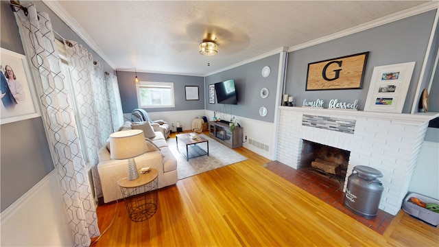 215 E Winter Ave, Danville, IL 61832 - living room featuring wood finished floors, ornamental molding, a brick fireplace, wainscoting, and ceiling fan