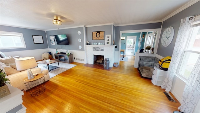 215 E Winter Ave, Danville, IL 61832 - living area featuring light wood-type flooring, a brick fireplace, and crown molding