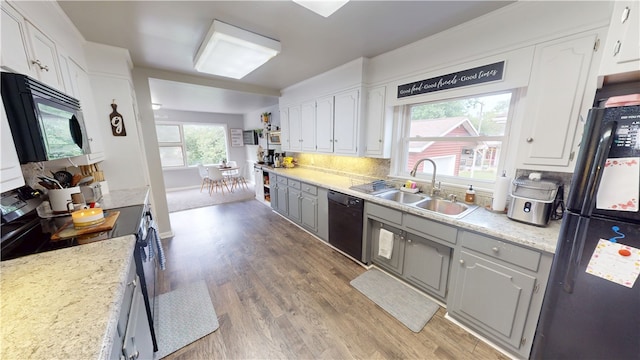 215 E Winter Ave, Danville, IL 61832 - kitchen featuring black appliances, light wood finished floors, white cabinets, and tasteful backsplash