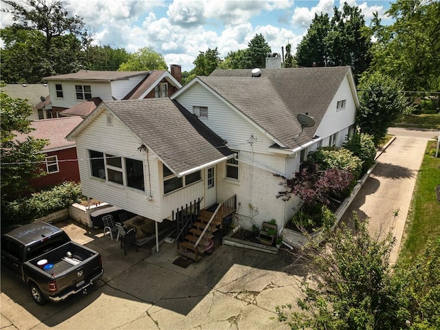 215 E Winter Ave, Danville, IL 61832 - rear view of property featuring a shingled roof, a patio, and a chimney