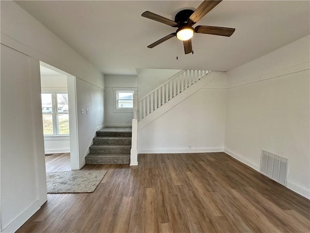 stairs featuring hardwood / wood-style flooring and ceiling fan