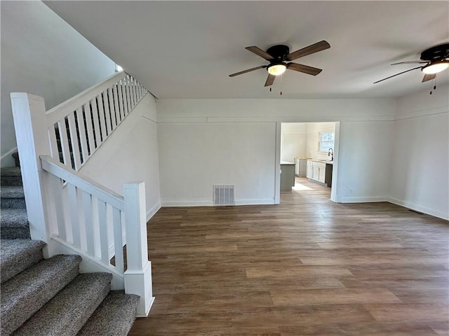 unfurnished living room featuring ceiling fan, sink, and hardwood / wood-style floors