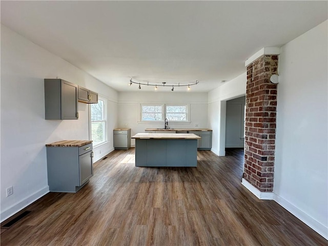 kitchen featuring sink, a center island, gray cabinetry, and dark hardwood / wood-style flooring