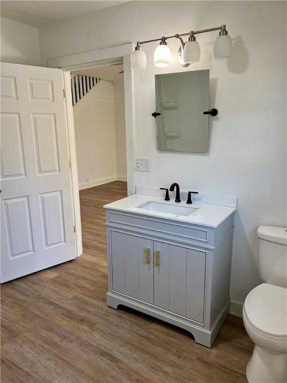 bathroom with hardwood / wood-style flooring, vanity, and toilet