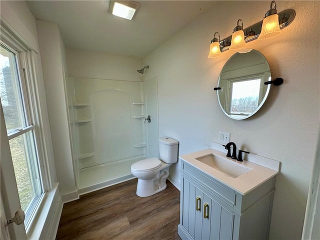 bathroom featuring wood-type flooring, toilet, vanity, and walk in shower