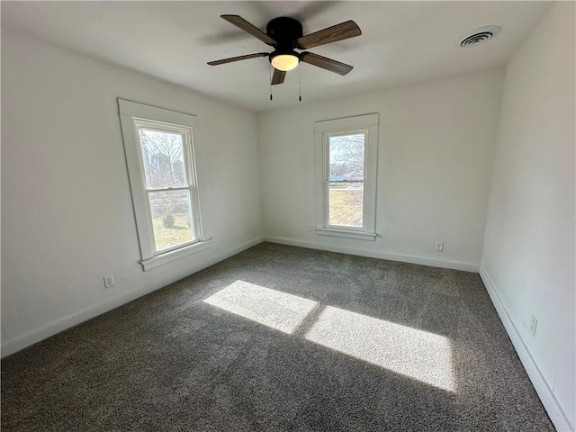 carpeted empty room with a wealth of natural light and ceiling fan