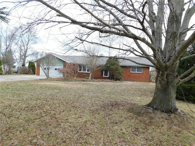 ranch-style house featuring a garage, brick siding, a front lawn, and fence