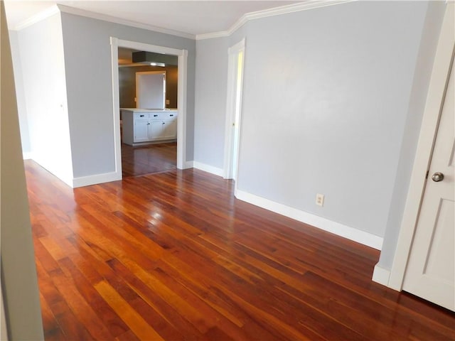 unfurnished room with baseboards, dark wood finished floors, and crown molding