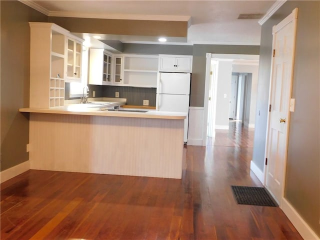 kitchen with a peninsula, open shelves, dark wood finished floors, and freestanding refrigerator