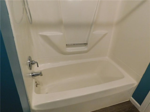 bathroom featuring  shower combination, baseboards, and wood finished floors