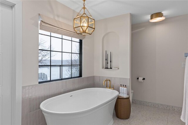 kitchen with white cabinetry, a barn door, dishwasher, hanging light fixtures, and sink