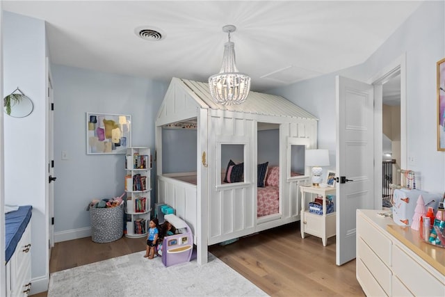 bedroom featuring wood-type flooring and a chandelier