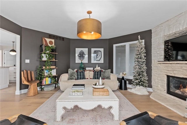 living room featuring light wood-type flooring and a fireplace