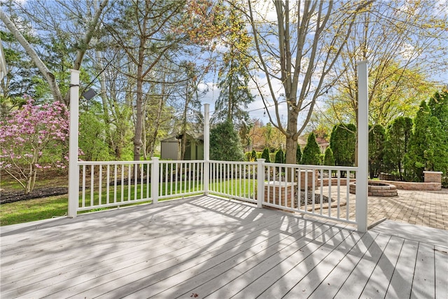 deck featuring a storage shed, an outbuilding, and a fire pit