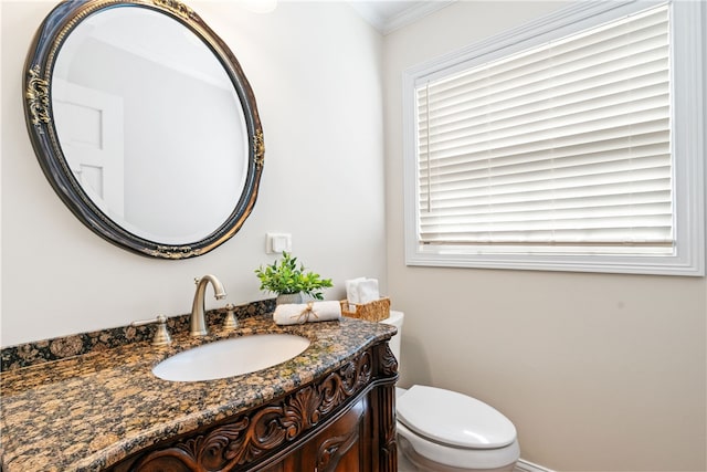 half bathroom featuring crown molding, vanity, and toilet