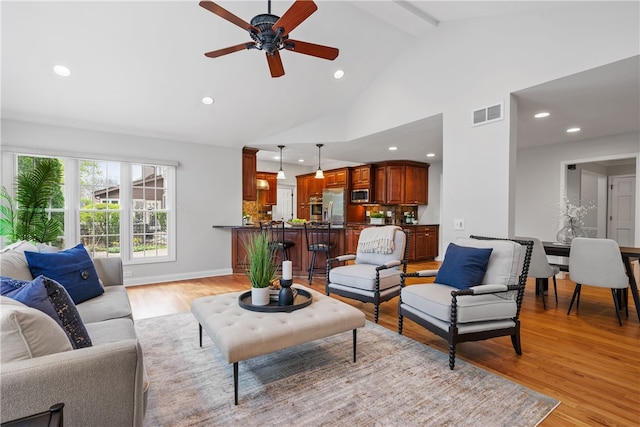 living room with ceiling fan, visible vents, high vaulted ceiling, light wood-style floors, and recessed lighting