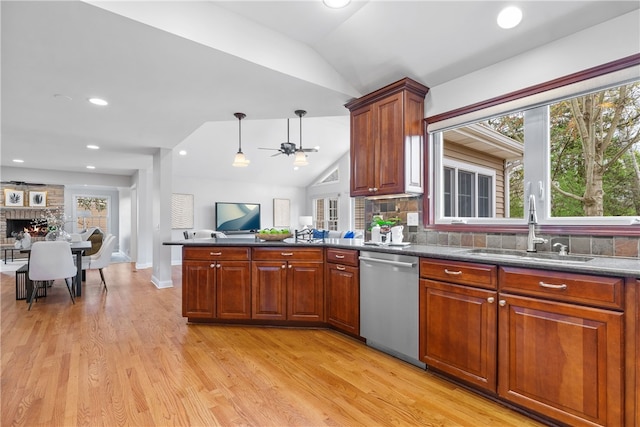 kitchen with a sink, light wood finished floors, dishwasher, open floor plan, and lofted ceiling