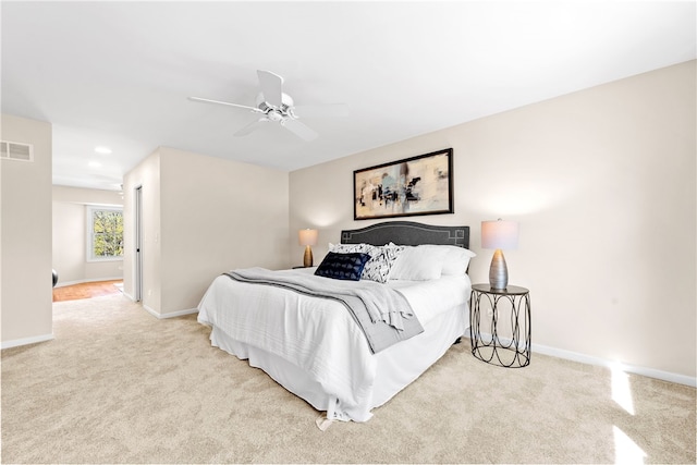 carpeted bedroom featuring baseboards, a ceiling fan, and visible vents