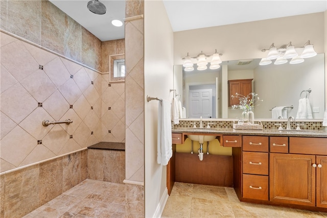 bathroom featuring double vanity, visible vents, a sink, a walk in shower, and tile patterned floors