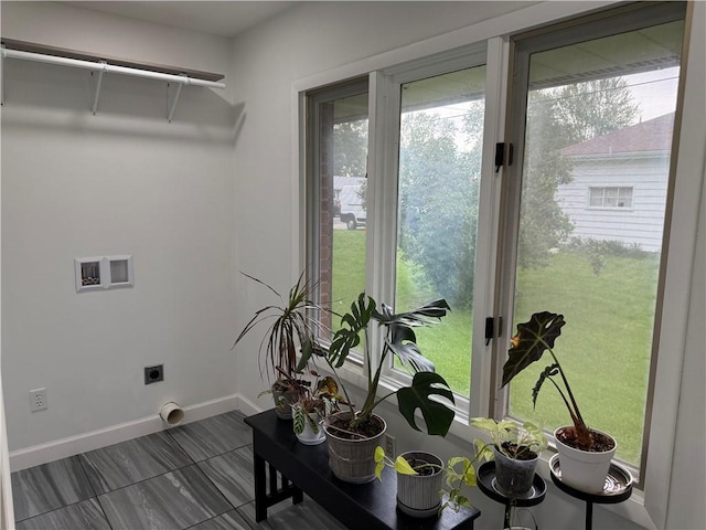 clothes washing area with electric dryer hookup, hookup for a washing machine, baseboards, and plenty of natural light