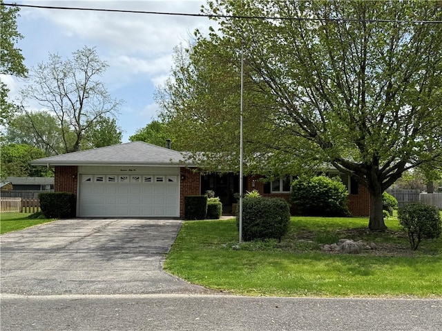 single story home with fence, an attached garage, a front lawn, brick siding, and aphalt driveway