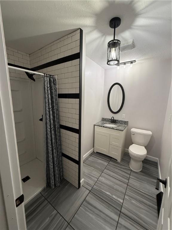 full bath featuring vanity, a textured ceiling, curtained shower, and toilet