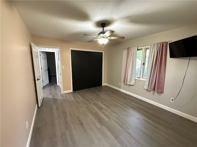 unfurnished bedroom featuring a ceiling fan, baseboards, and wood finished floors