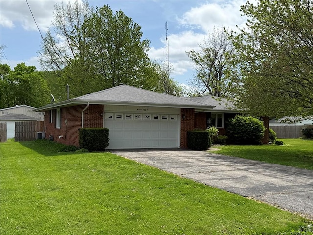 single story home with fence, aphalt driveway, a garage, brick siding, and a front yard
