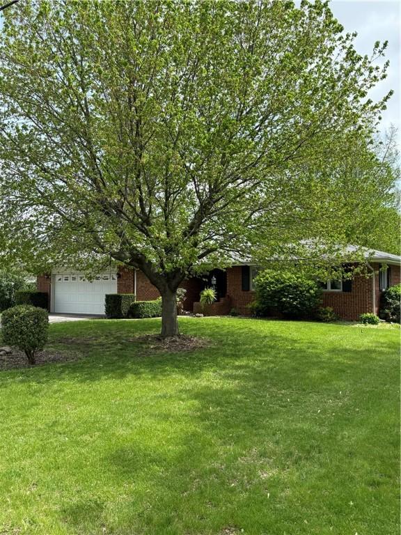view of front of home with an attached garage and a front lawn