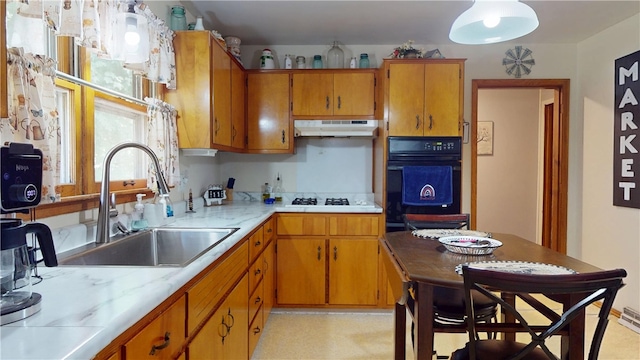 714 Parras St, Danville, IL 61832 - kitchen with oven, under cabinet range hood, brown cabinets, light countertops, and cooktop