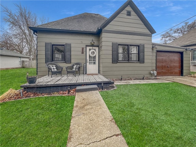 view of front of house featuring a garage, concrete driveway, roof with shingles, and a front yard