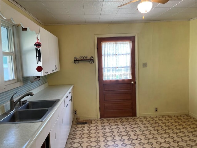 510 W Elm St, Hoopeston, IL 60942 - kitchen featuring ceiling fan, white cabinets, light countertops, crown molding, and tasteful backsplash