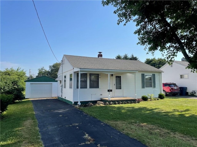 510 W Elm St, Hoopeston, IL 60942 - view of front facade featuring an outdoor structure, a detached garage, a front yard, a porch, and asphalt driveway