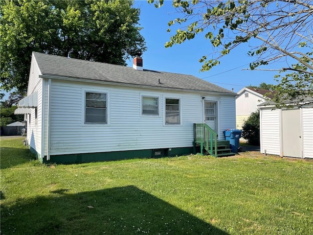 510 W Elm St, Hoopeston, IL 60942 - back of house with a chimney, a yard, a storage unit, and a shingled roof