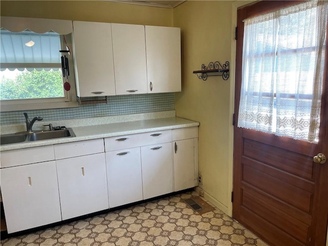 510 W Elm St, Hoopeston, IL 60942 - kitchen featuring light countertops, white cabinets, backsplash, and light flooring