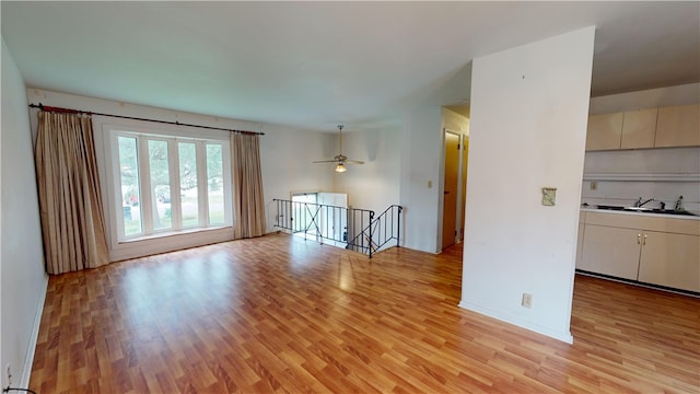 unfurnished room with light hardwood / wood-style floors, ceiling fan, and sink