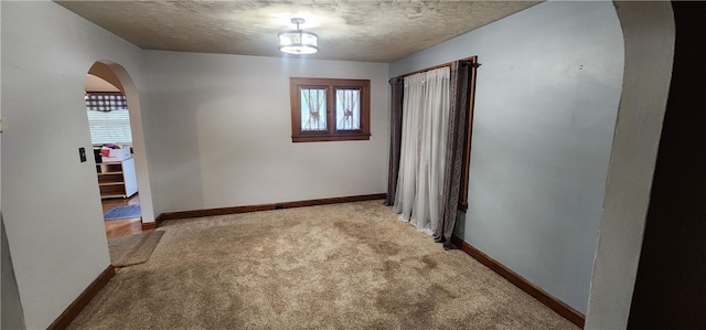 hall featuring light colored carpet and a textured ceiling