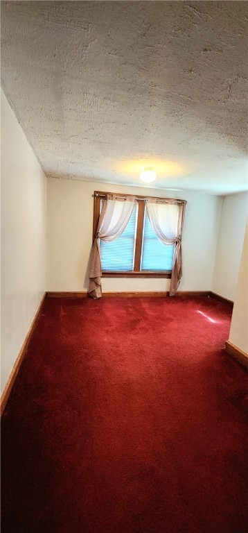 spare room with a textured ceiling and carpet floors