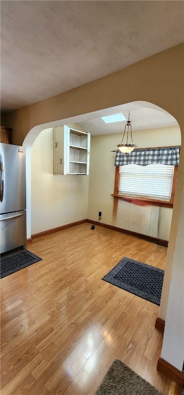 interior space with a skylight and hardwood / wood-style floors