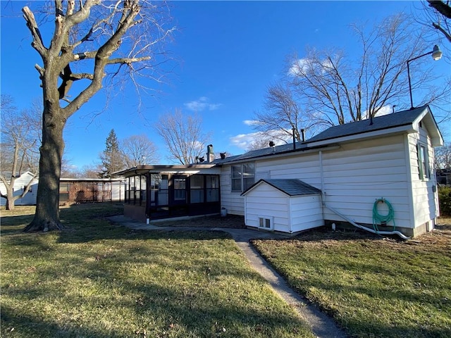 rear view of property featuring a sunroom and a yard