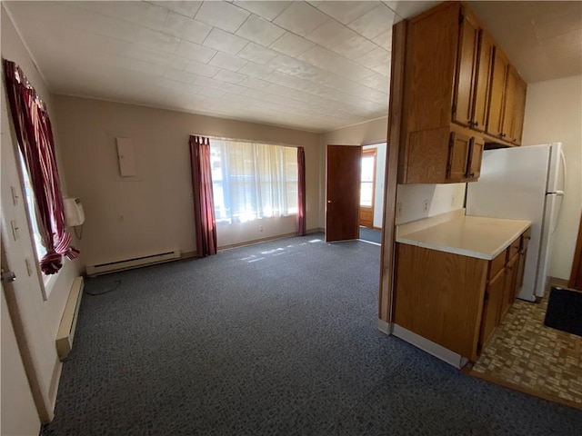 kitchen featuring a baseboard radiator, brown cabinets, light countertops, and freestanding refrigerator