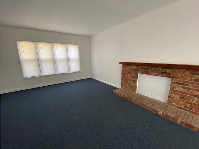 unfurnished living room featuring a fireplace, dark carpet, and baseboards