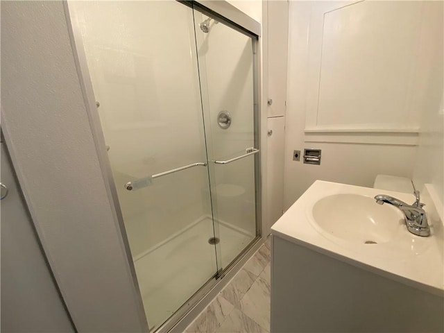 full bath featuring a stall shower, marble finish floor, and vanity