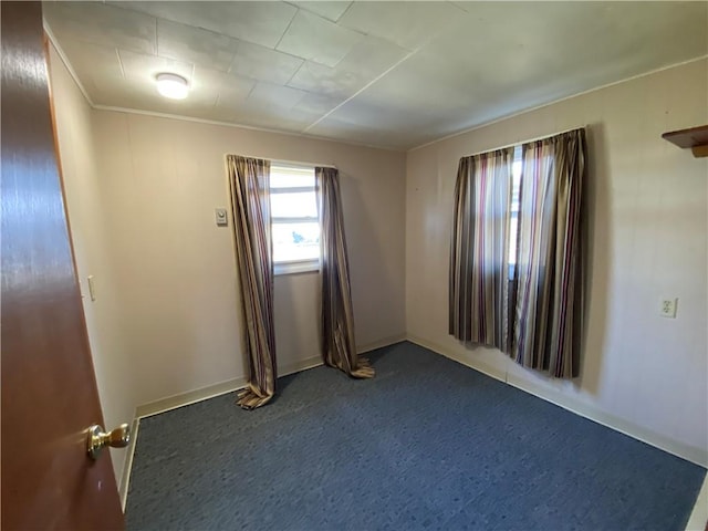 unfurnished room featuring dark carpet