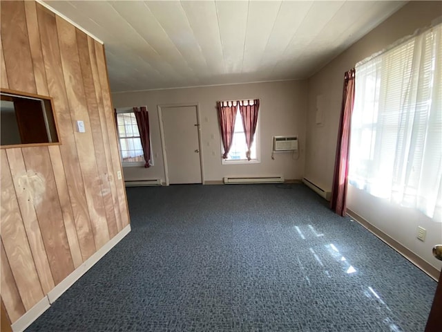 spare room with wood walls, baseboard heating, a baseboard radiator, and a wall mounted air conditioner