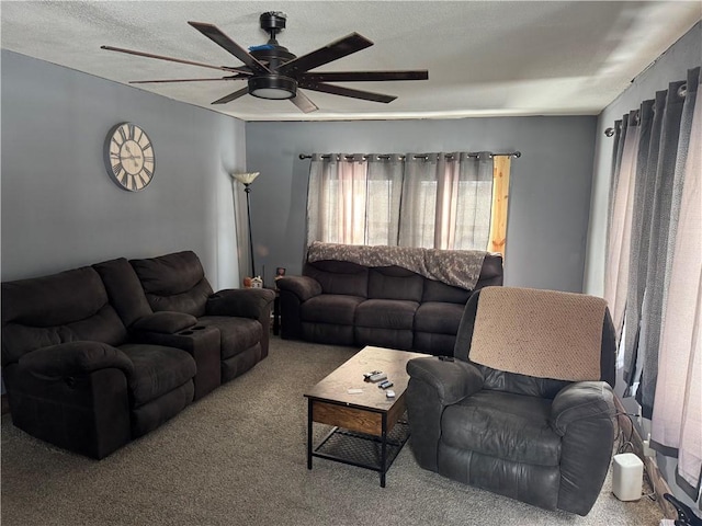 carpeted living room featuring ceiling fan and a textured ceiling