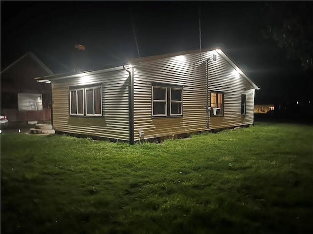 property exterior at night with a yard