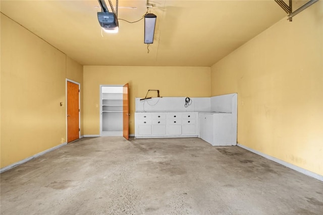 garage featuring a garage door opener and baseboards