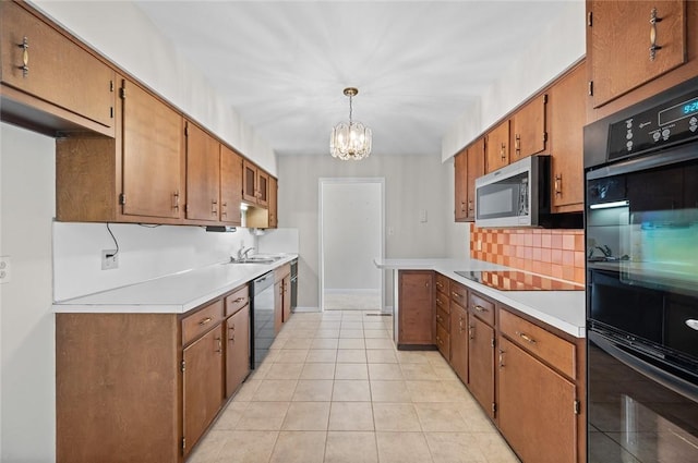 kitchen with black appliances, decorative backsplash, light countertops, a chandelier, and brown cabinetry